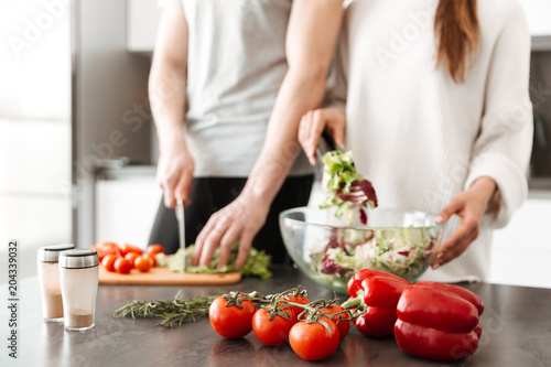Close up portrait of a young couple cooking salad