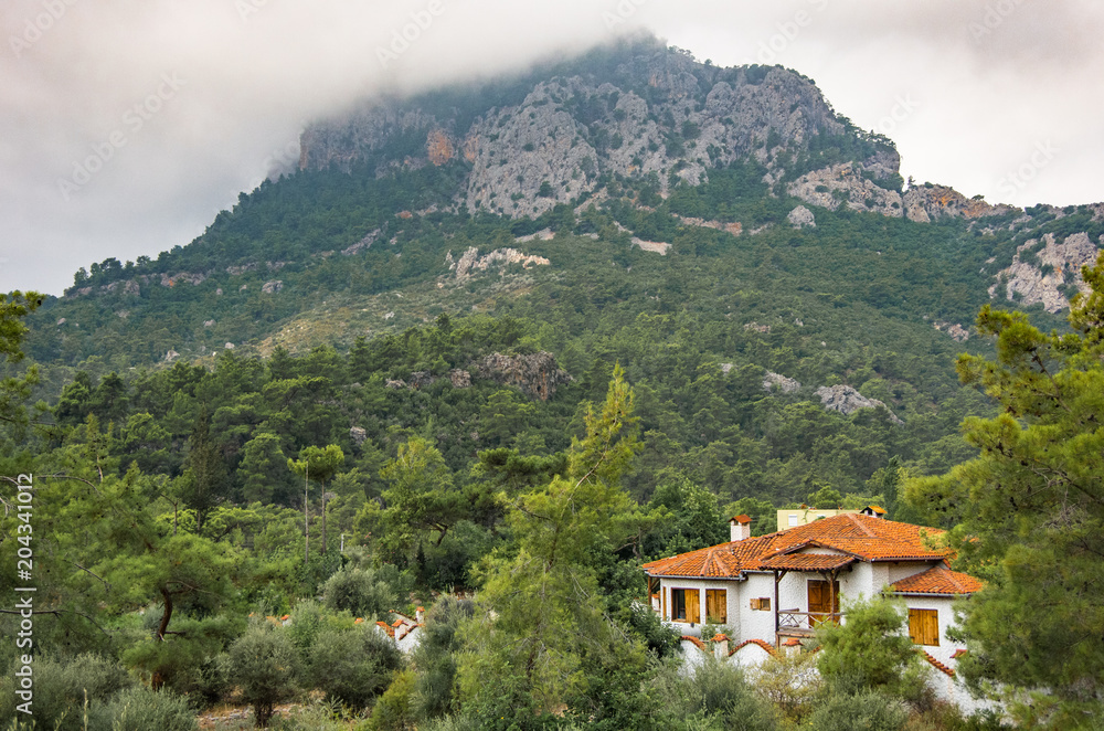 White House with a tiled roof at the foot of the mountain White House with a tiled roof at the foot of the mountain