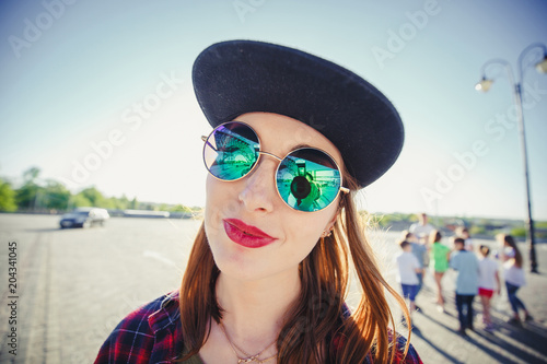 amazed girl in green glasses with reflection and cap is looking at camera. summer time concept. summer is coming. fun on the street or beach © Oleksandr