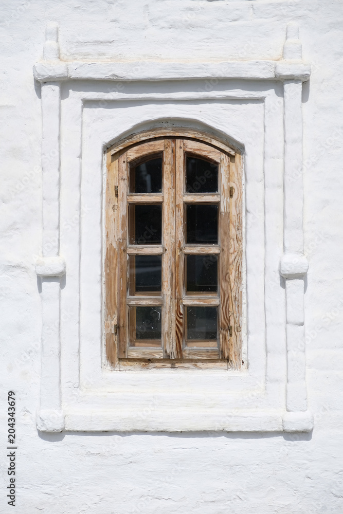Old brown wooden window on white ancient historical house wall. Old brown wooden window on white ancient historical house wall.