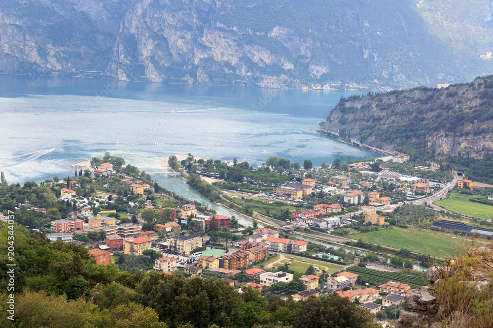 Panorama of Lake Garda, lakeside village Torbole and mountains, Italy