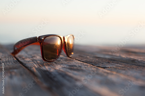 Wallpaper Mural Brown sunglasses on a wooden table outdoors in the sunlight Torontodigital.ca
