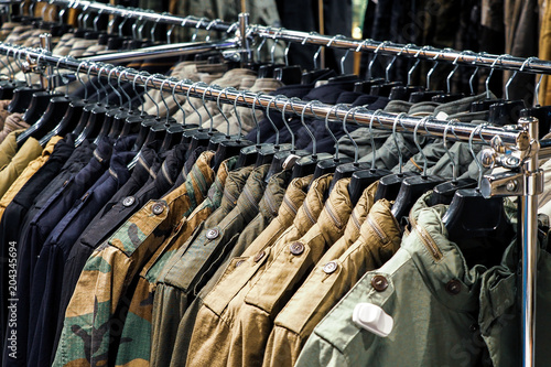 Things are men's clothes on hangers in a trendy clothes store. Clothes on a hanger in a fashion boutique. Selective focus. Shopping concept. men's military clothing khaki