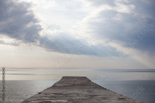 Fototapeta Naklejka Na Ścianę i Meble -  Beautiful cloudy sky, sea, pier and sun rays