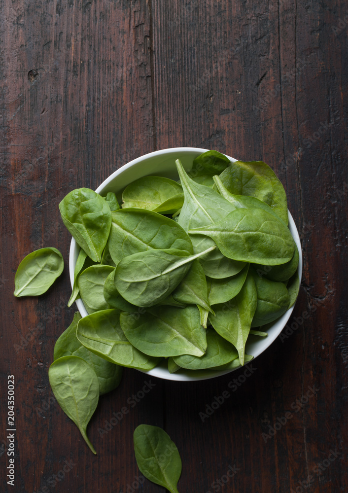 spinach leaves on a dark wood background spinach leaves on a dark wood background