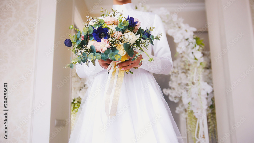 Attractive bride in white dress holding a bouquet of flowers Attractive bride in white dress holding a bouquet of flowers