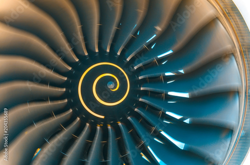 Background turbine blades rotate jet engine aircraft close up.