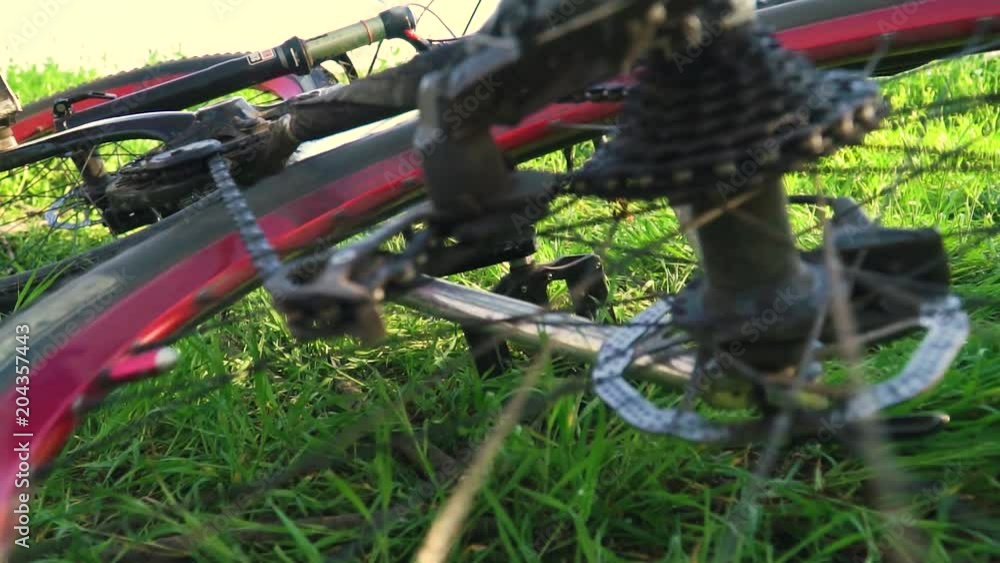 Slow motion shooting a bicycle in the grass at which the wheel is spinning Slow motion shooting a bicycle in the grass at which the wheel is spinning