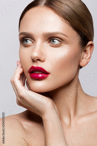 Beautiful young model with red lips and nude manicure