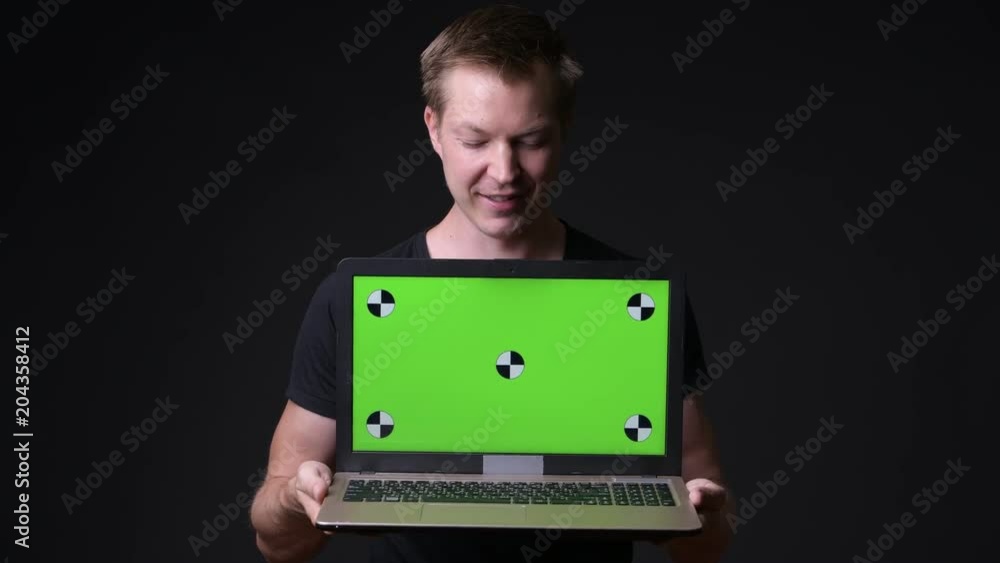 Young handsome man using laptop with green screen chroma key Young handsome man using laptop with green screen chroma key