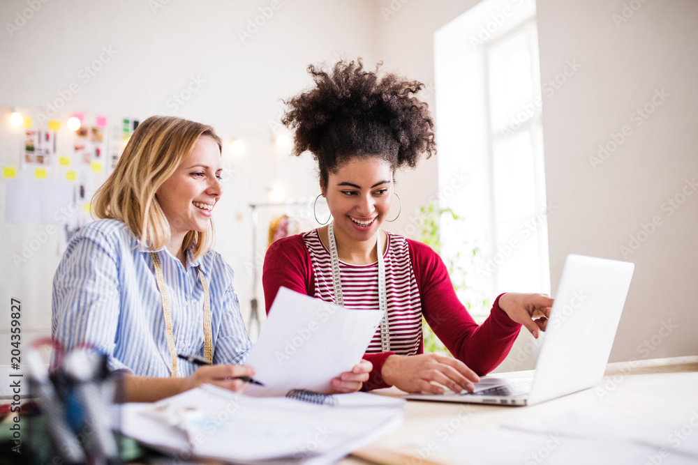 Young creative women with laptop in a studio, startup business. Young creative women with laptop in a studio, startup business.