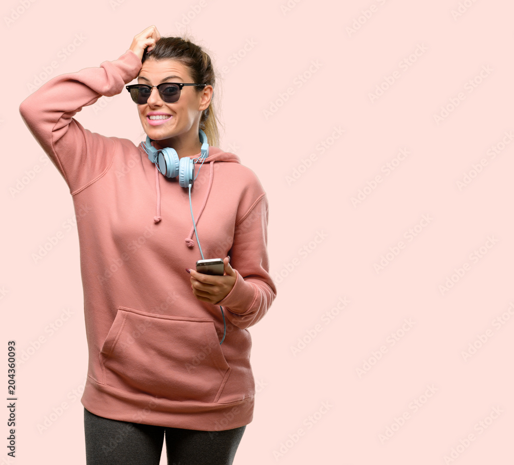 Young sport woman with headphones and sunglasses raising finger, the number one Young sport woman with headphones and sunglasses raising finger, the number one