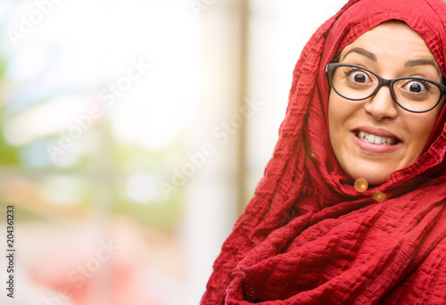 Young arab woman wearing hijab confident and happy with a big crazy smile laughing