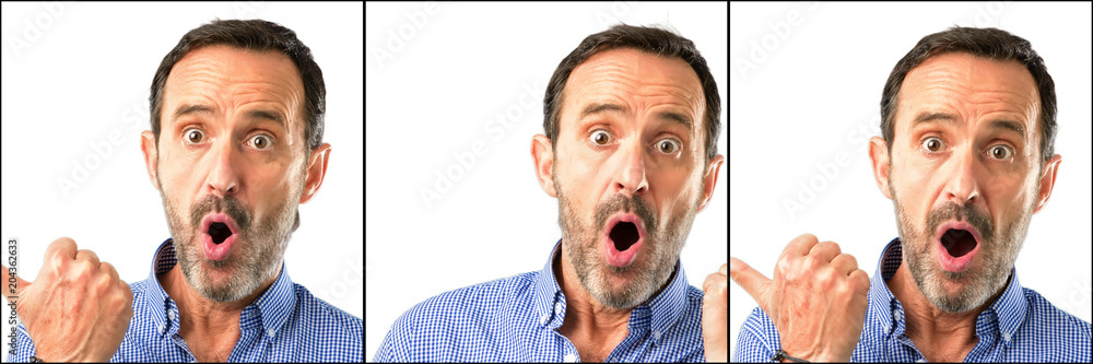 Middle age handsome man closeup happy and surprised cheering expressing wow gesture pointing up Middle age handsome man closeup happy and surprised cheering expressing wow gesture pointing up