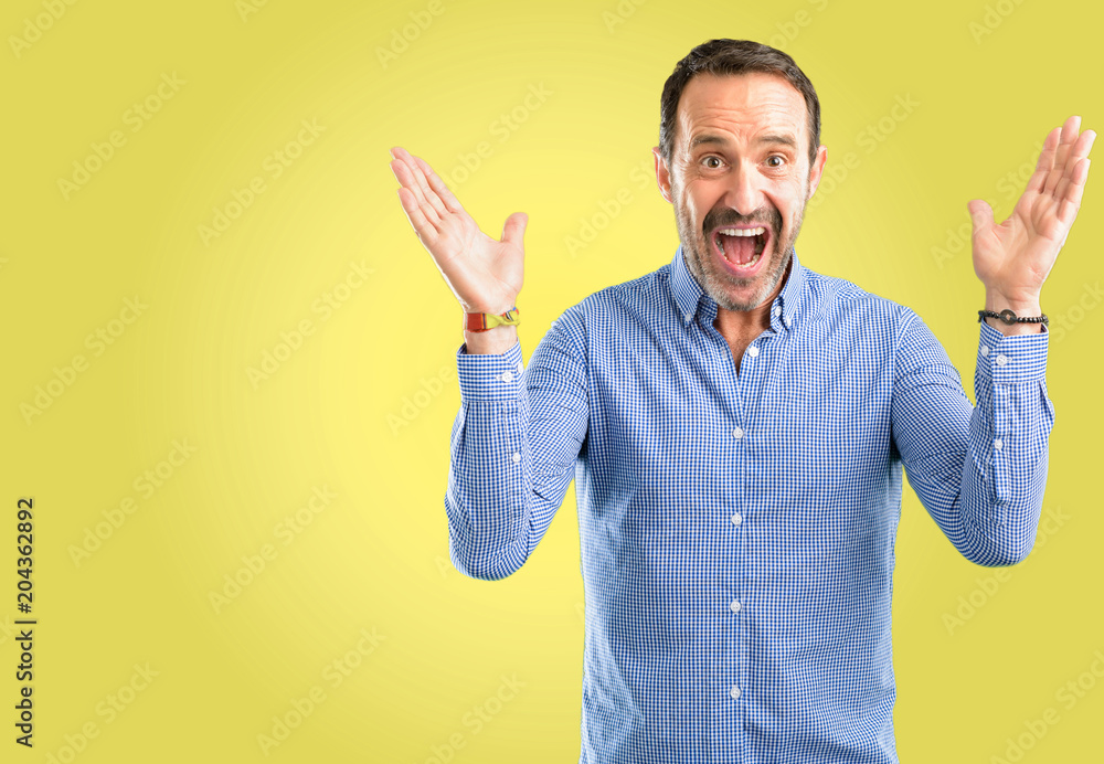 Handsome middle age man happy and surprised cheering expressing wow gesture Handsome middle age man happy and surprised cheering expressing wow gesture