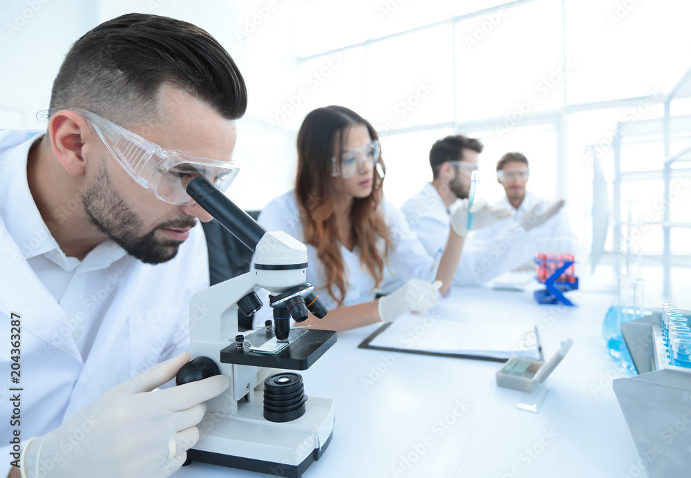 Fototapeta premium male laboratory technician looking at samples in the microscope