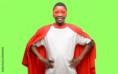 African black super hero man confident and happy with a big natural smile laughing