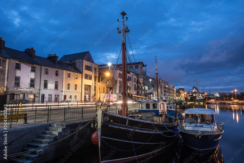 Fishing boat trawlers docked in Galway bay harbour at night
