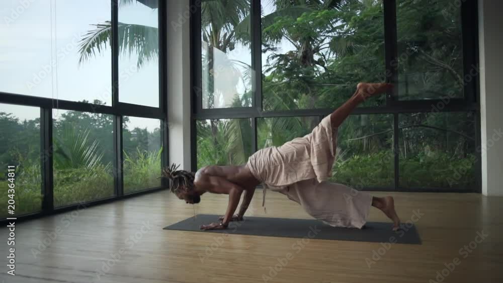 Man do downward facing dog to upward dog yoga pose in studio rapid slow motion Man do downward facing dog to upward dog yoga pose in studio rapid slow motion