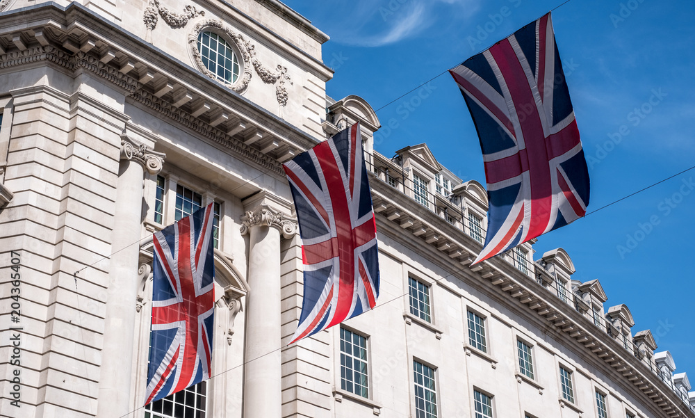 Close up of buildings on Regent Street London UK photographed from street level, with row of British flags to celebrate the Royal Wedding of Prince Harry to Meghan Markle.