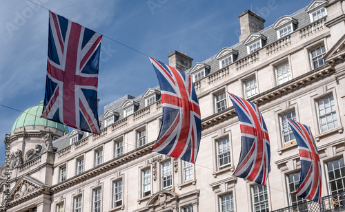 Close up of buildings on Regent Street London UK photographed from street level, with row of British flags to celebrate the Royal Wedding of Prince Harry to Meghan Markle.