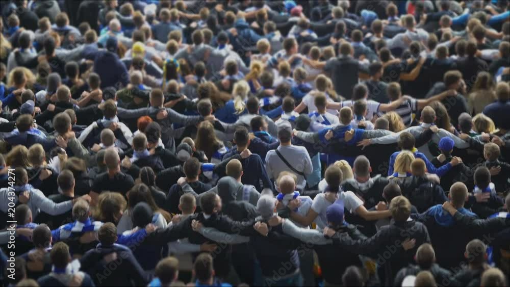 Happy football soccer fans hugging, dancing in joy at stadium, celebrating goal. Excited crowd jumping, celebrating victory, 4K