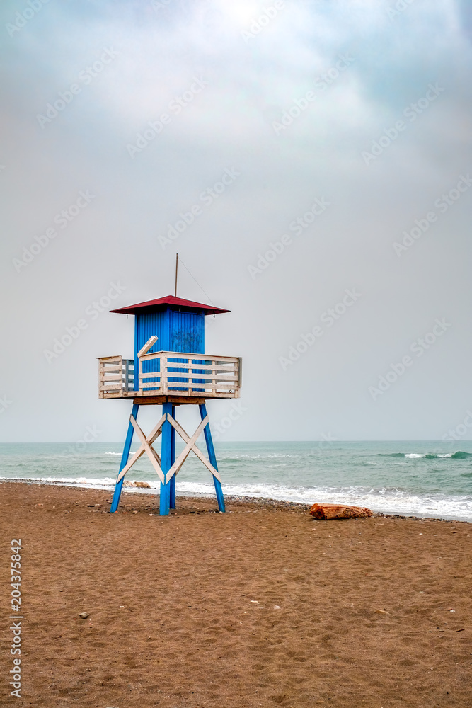 Mediterranean beach with vintage and lonely lifeguard wooden tower, De La Cala beach, Malaga, Spain