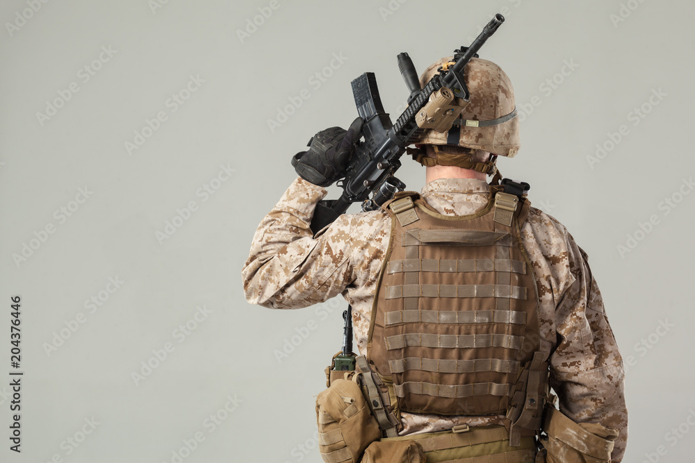 Soldier in camouflage holding rifle Soldier in camouflage holding rifle