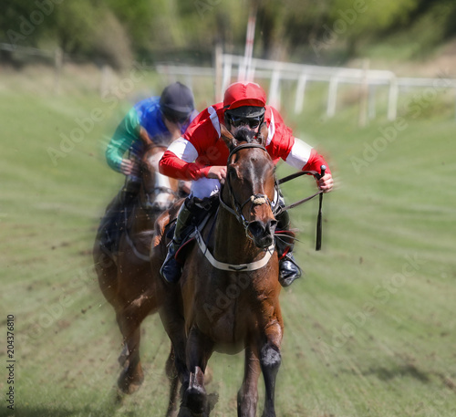 Lead race horse and jockey galloping at speed towards the finish line