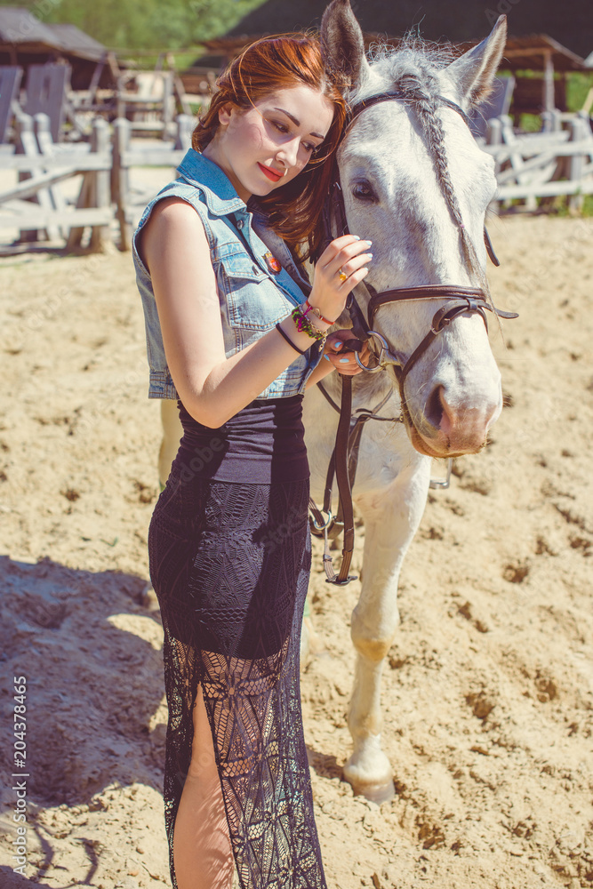 Portrait of  beautiful nice woman and horse near the horse farm. Concept people and animals. Girl with an horse together at the horse house 