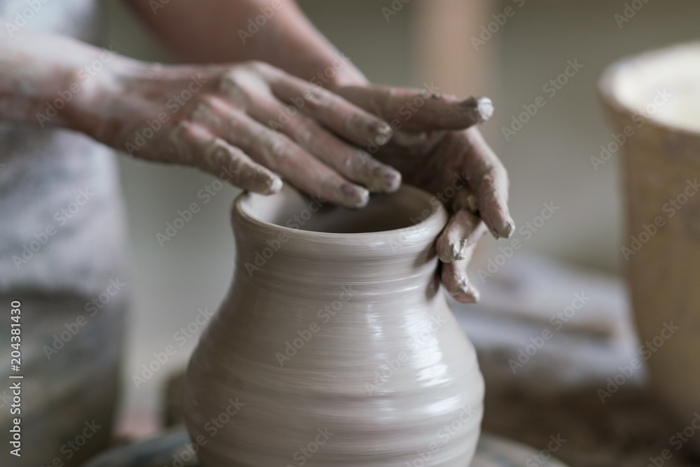 potter sculpts a vase on a potter's wheel potter sculpts a vase on a potter's wheel