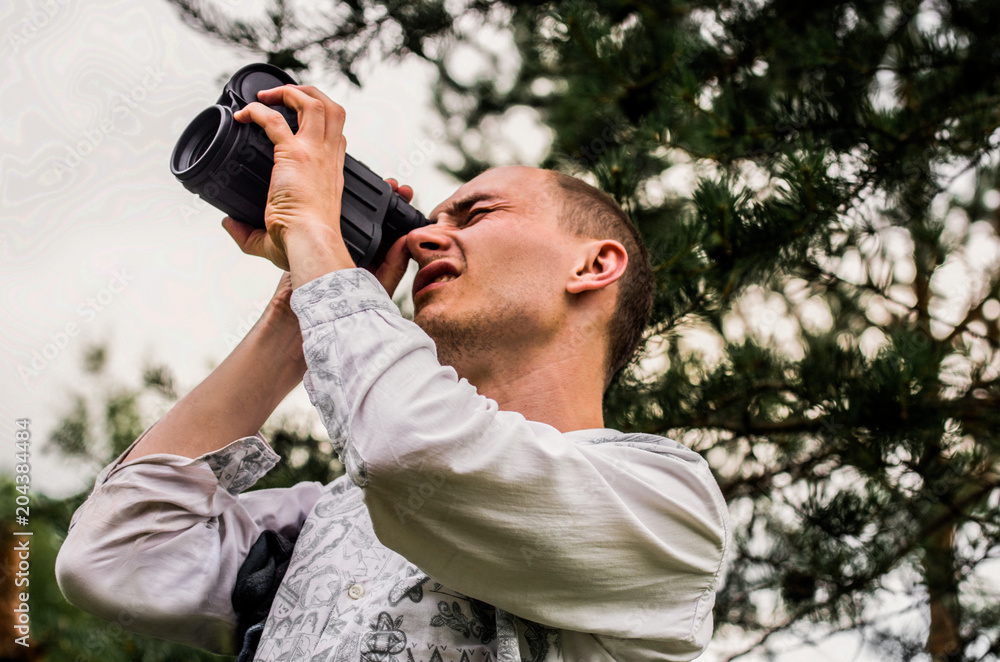 A man looks carefully through the monocular to the sky A man looks carefully through the monocular to the sky