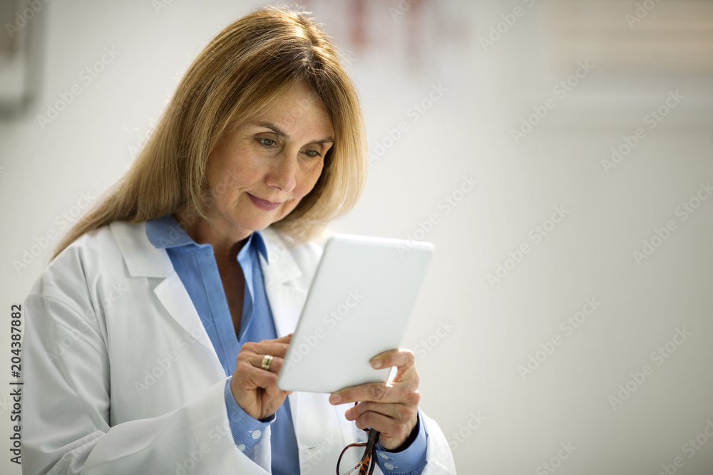 Mid adult doctor using a digital tablet. Mid adult doctor using a digital tablet.