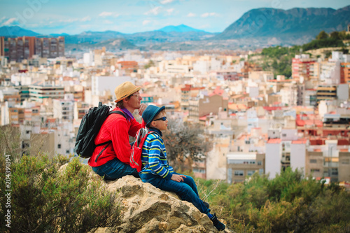father and son travel looking at scenic view over the city