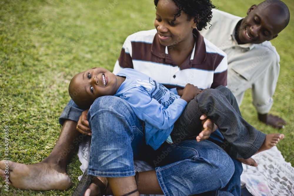 Portrait of a young boy having a picnic with his young adult mother and father. Portrait of a young boy having a picnic with his young adult mother and father.