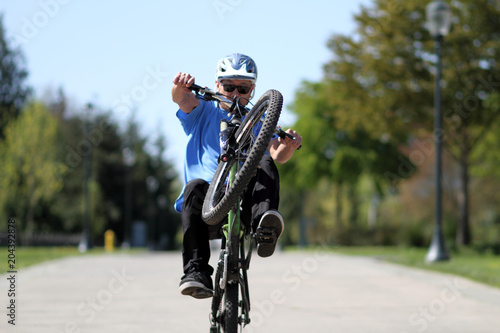 Man doing a wheelie on a bicycle.
