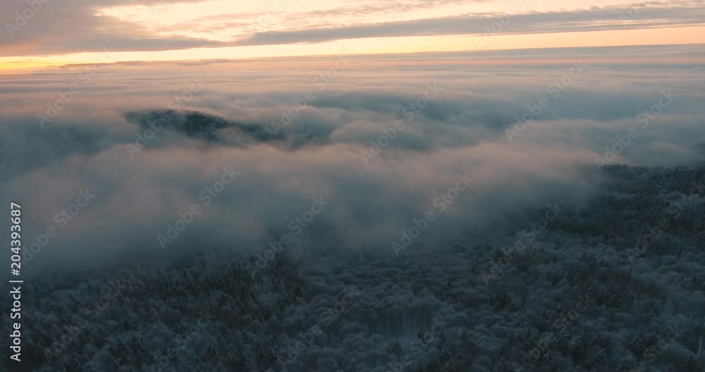 A mountain peeking through the wintery clouds A mountain peeking through the wintery clouds