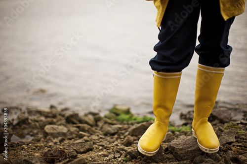 Person in gumboots standing on rocky shore photo