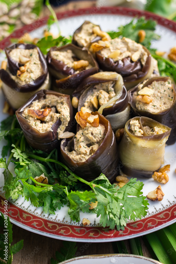 Roasted eggplant rolls with walnuts, garlic, coriander, oil, onion. Traditional Georgian food cold snack. Rolls for dinner or lunch. Raw vegan vegetarian healthy food Roasted eggplant rolls with walnuts, garlic, coriander, oil, onion. Traditional Georgian food cold snack. Rolls for dinner or lunch. Raw vegan vegetarian healthy food