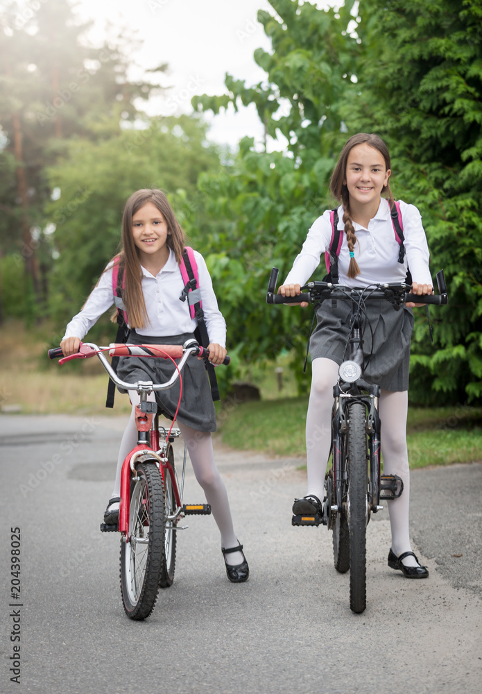 Fototapeta premium Two girls commuting to school on bicycles