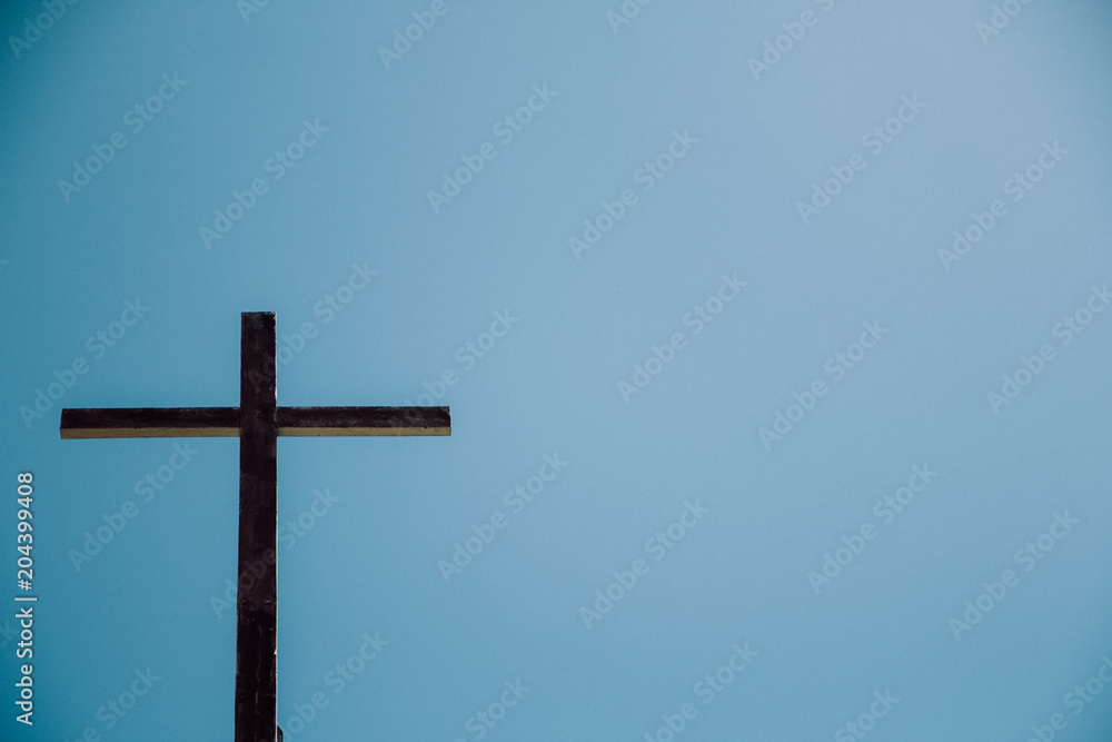 The Old wooden cross with the blue sky background.