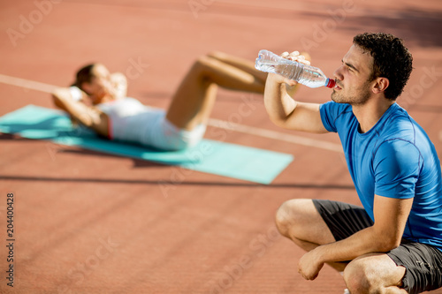 Sporty man drinking water w...