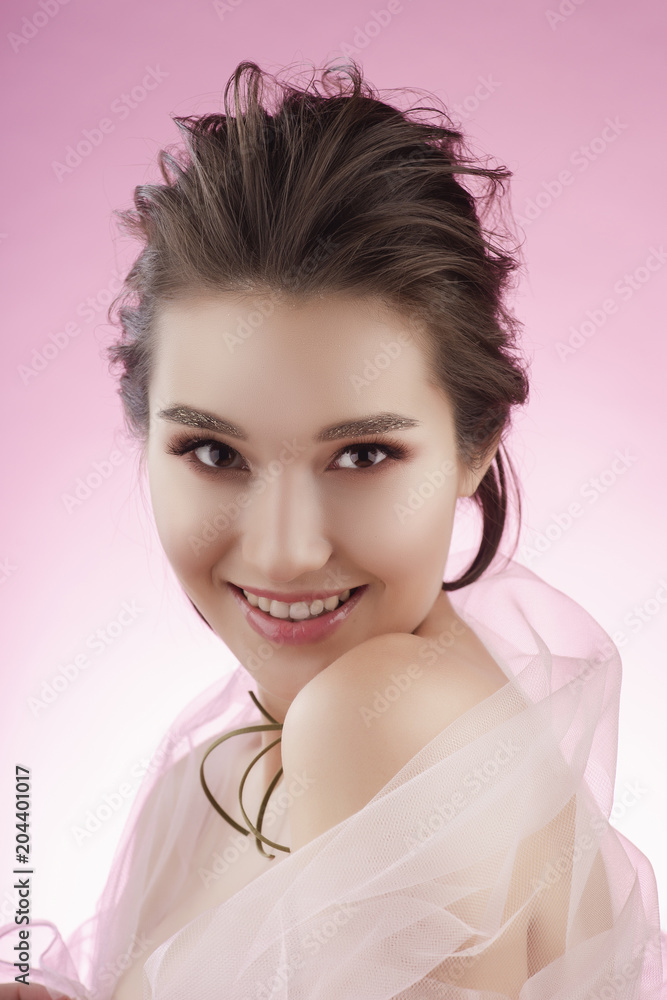 Closeup portrait of a beautiful smiling asian girl wearing pink veil on her shoulders and a choker on her neck