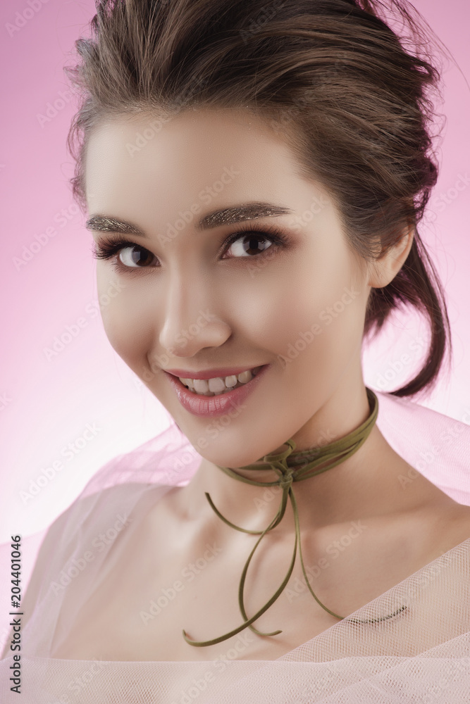 Closeup portrait of a beautiful smiling asian girl wearing pink veil on her shoulders and a choker on her neck Closeup portrait of a beautiful smiling asian girl wearing pink veil on her shoulders and a choker on her neck