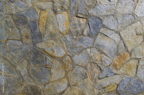 Rough grey and beige stone wall cell texture. Background. Interior design.