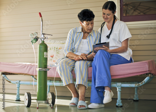 Nurse showing notes to her elderly patient.