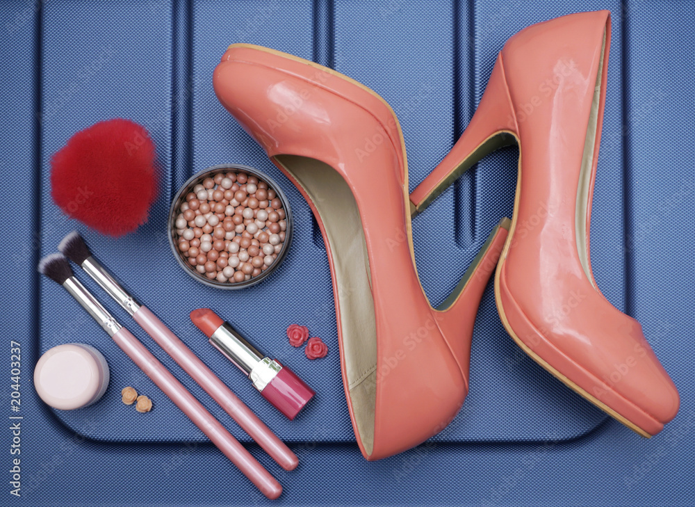 Cosmetic product, make up accessories and woman shoes in the blue background. Beauty treatment before vacation Cosmetic product, make up accessories and woman shoes in the blue background. Beauty treatment before vacation