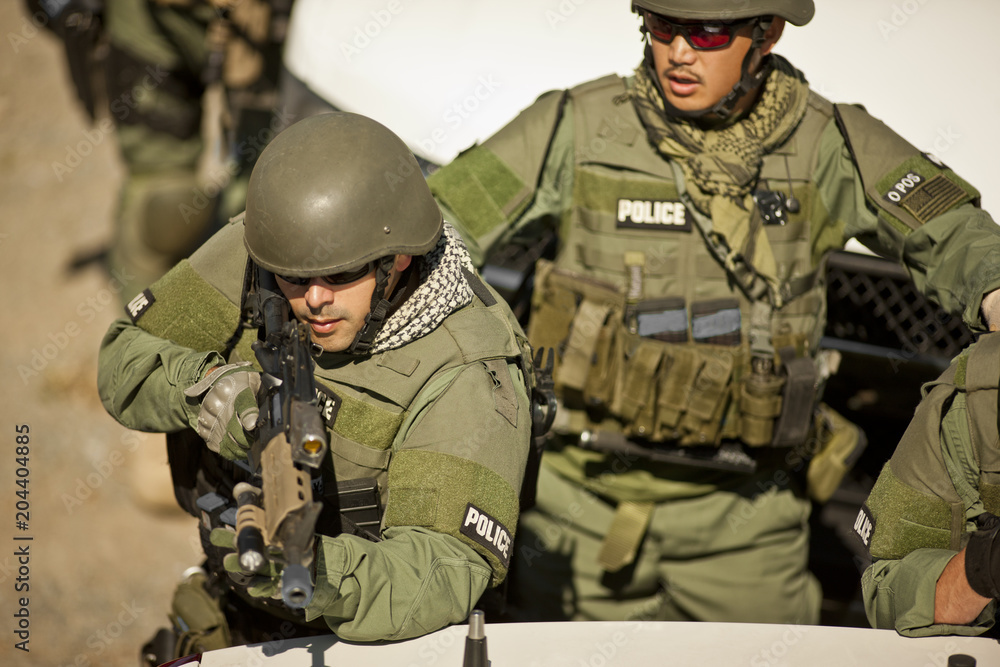 Male police officer aiming a gun toward a target during an exercise at a training facility. Male police officer aiming a gun toward a target during an exercise at a training facility.