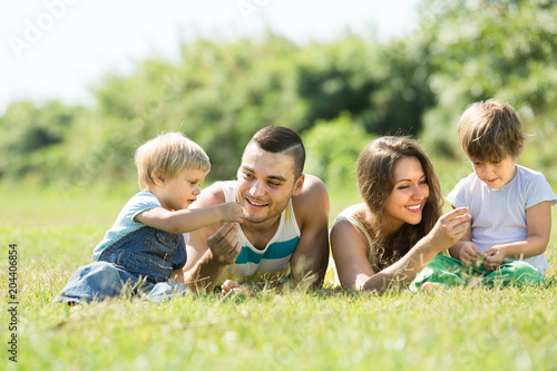 Family of four in grass at park