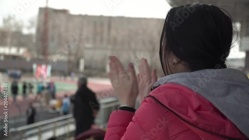 Brunette girl, the fan at the stadium is happy, the goal scored. A girl of oriental appearance, a beautiful girl